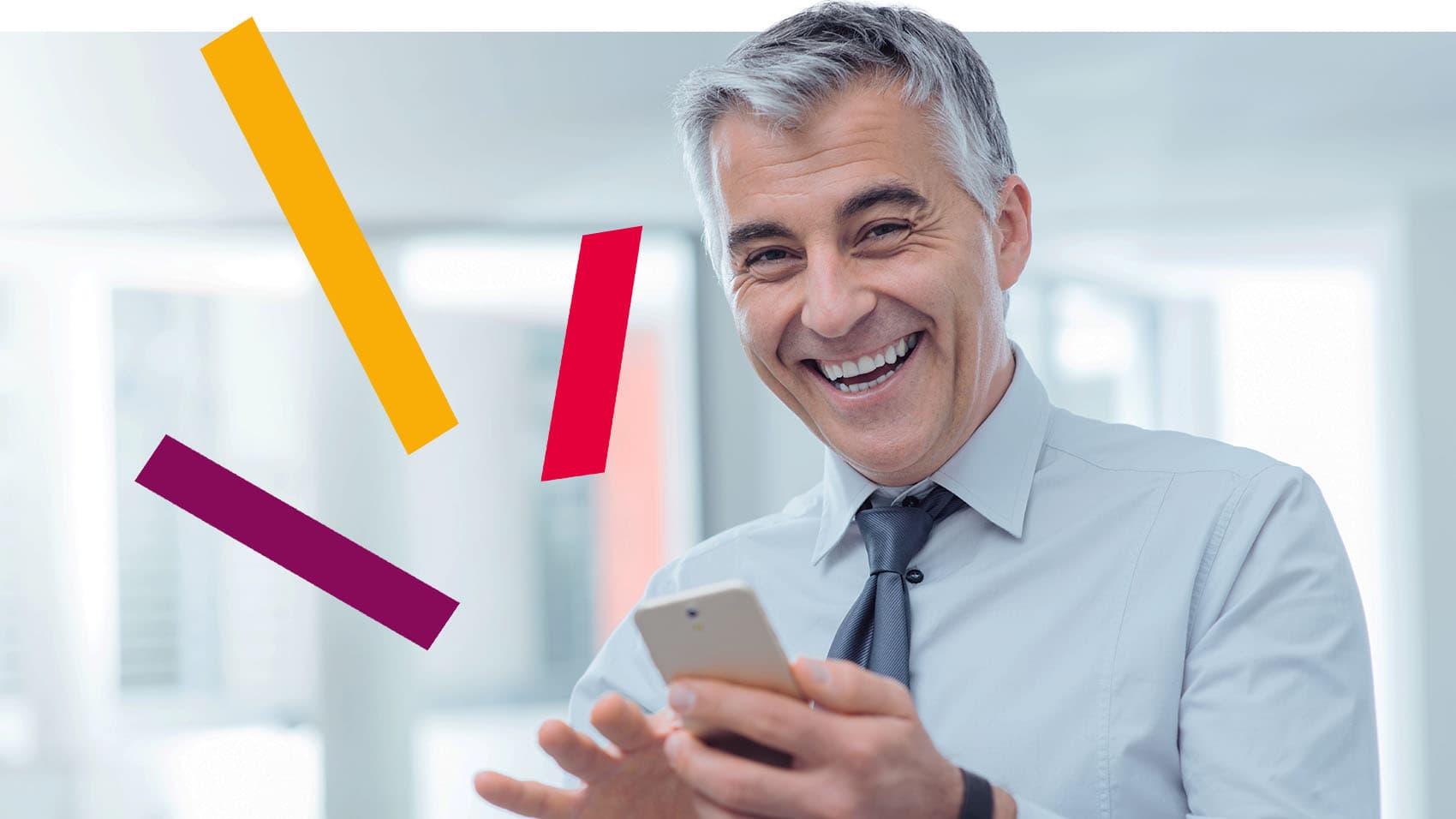 Mann hält Mobiltelefon und lacht