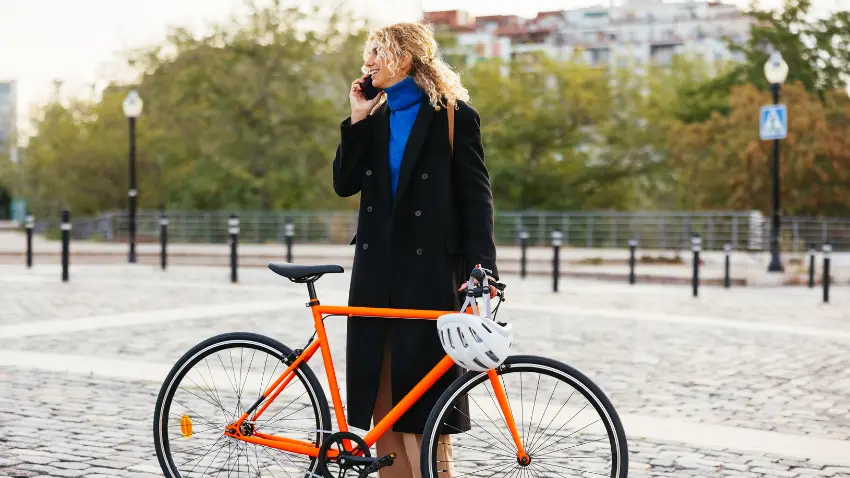 Woman on phone with a bike during work commute